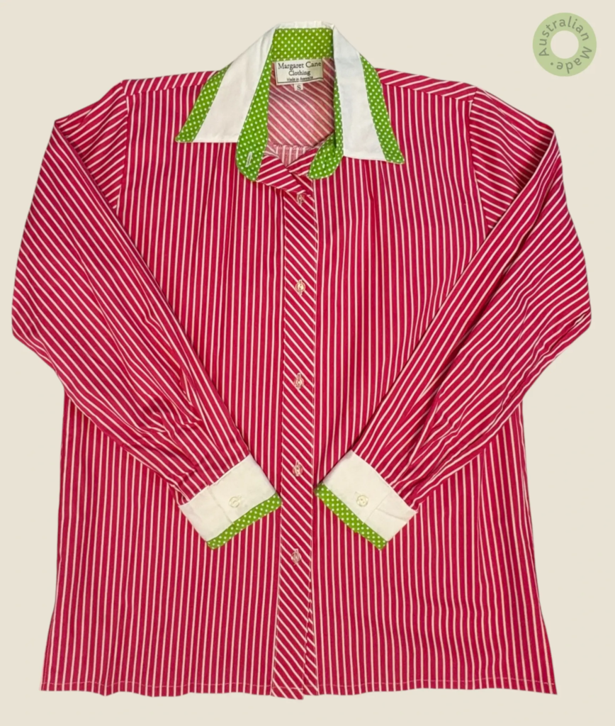 #234 – This vibrant red shirt features an all-over large white polka dot print. It is d