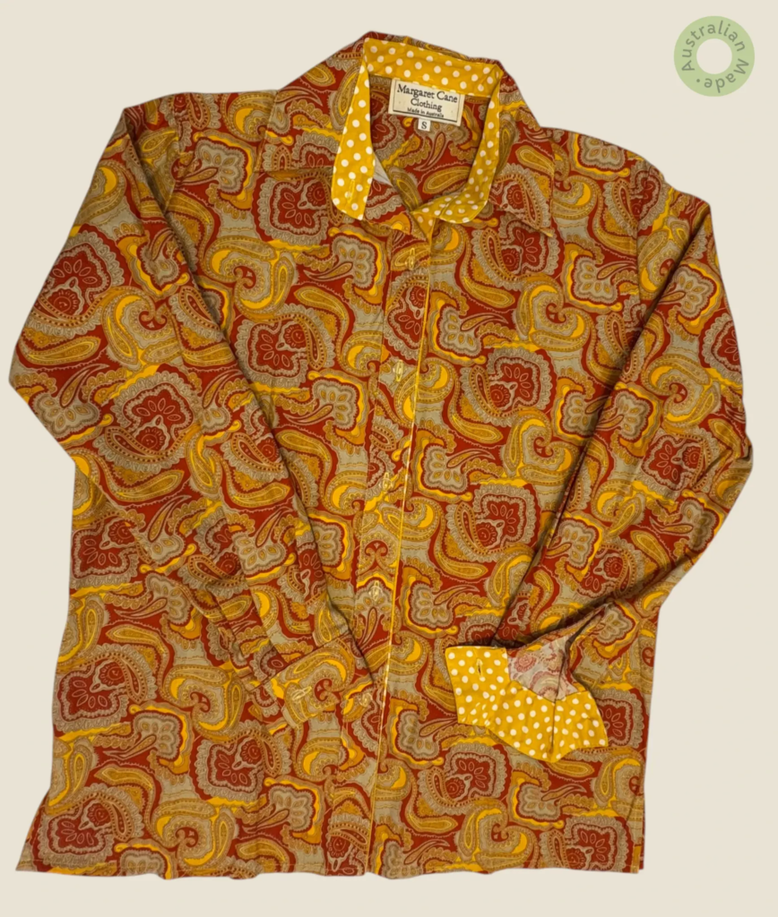 #411 – This shirt features an intricate all-over paisley print in shades of rust, ochre