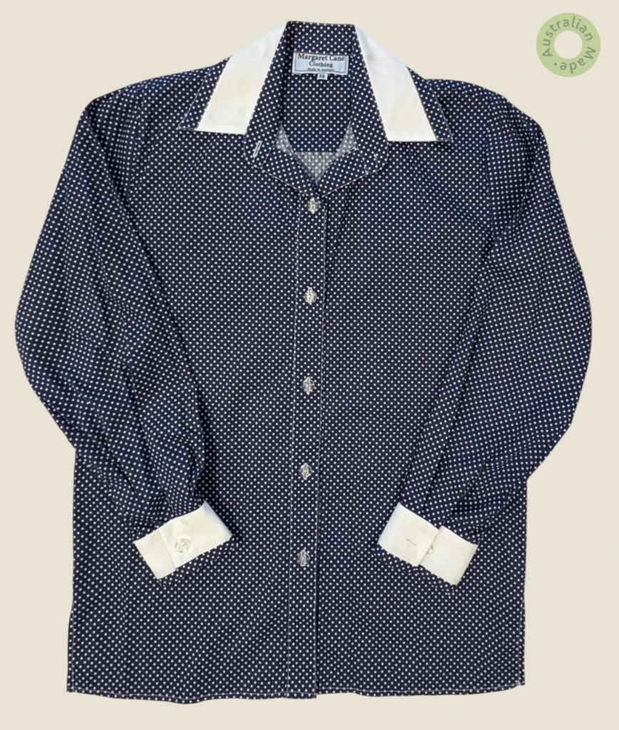 #250 – This shirt features a navy base with a white polka dot pattern throughout the ma