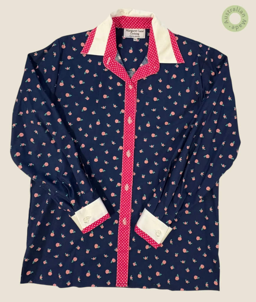 #233 – This shirt features a navy base with a pink rosebud floral pattern throughout th