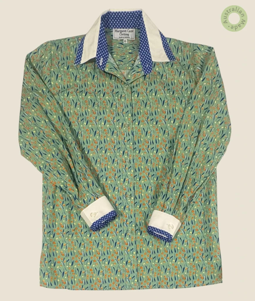 #258 – This shirt features a light green base with a dense orange and blue wildflower p