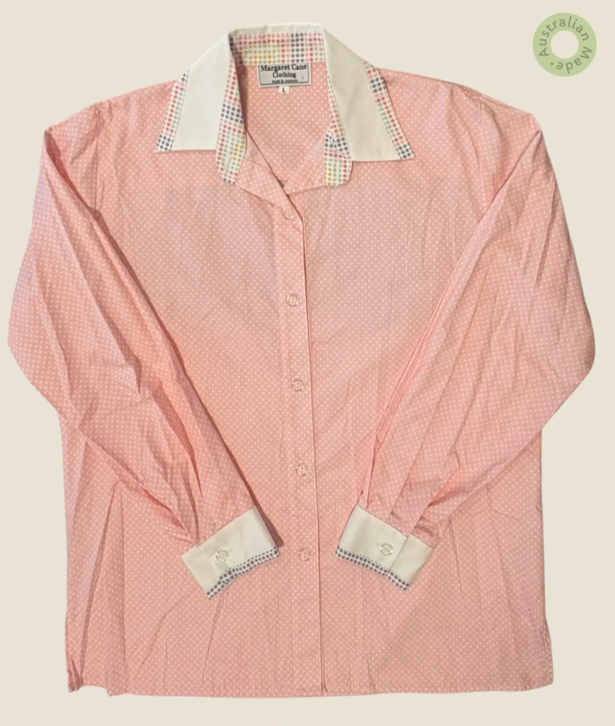 #273 – This shirt features a pink base with small white polka dot pattern throughout th