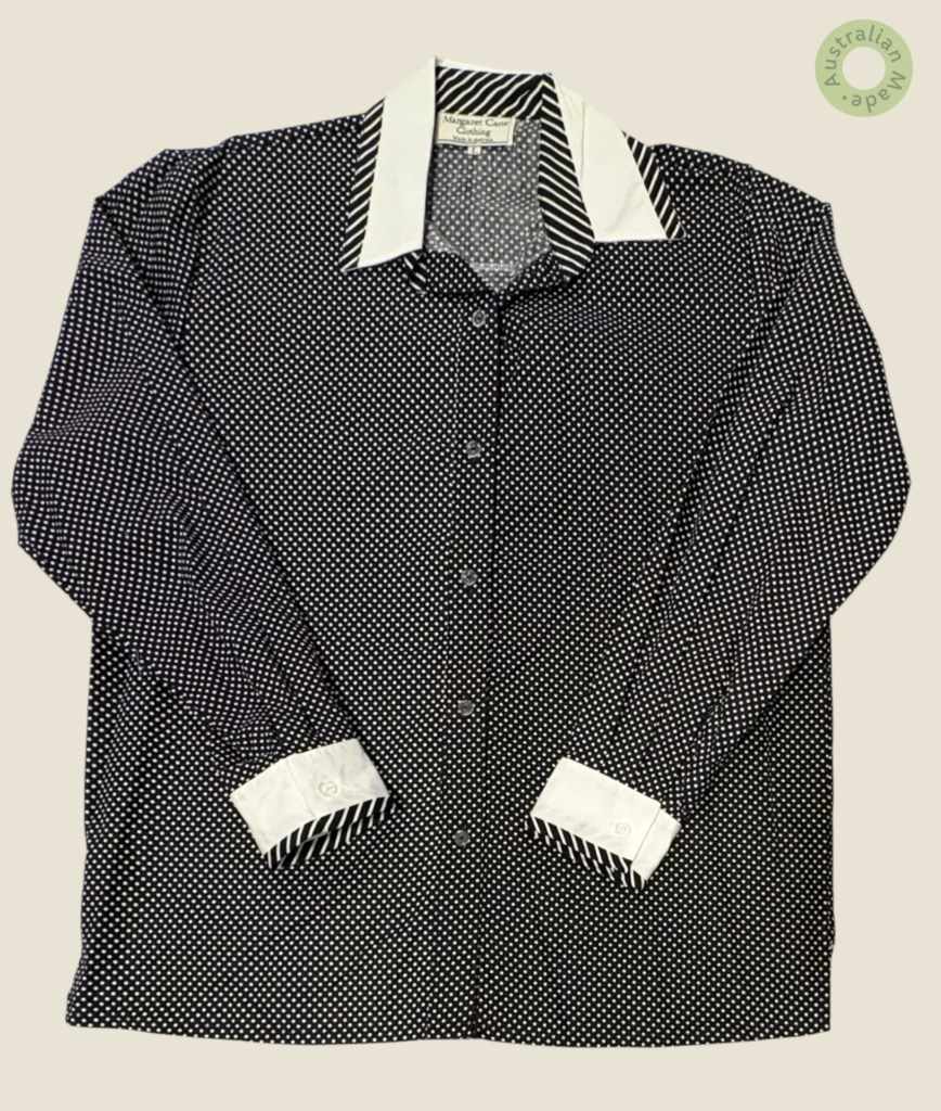 #282 – This shirt features a black base with a dense small white polka dot pattern thro