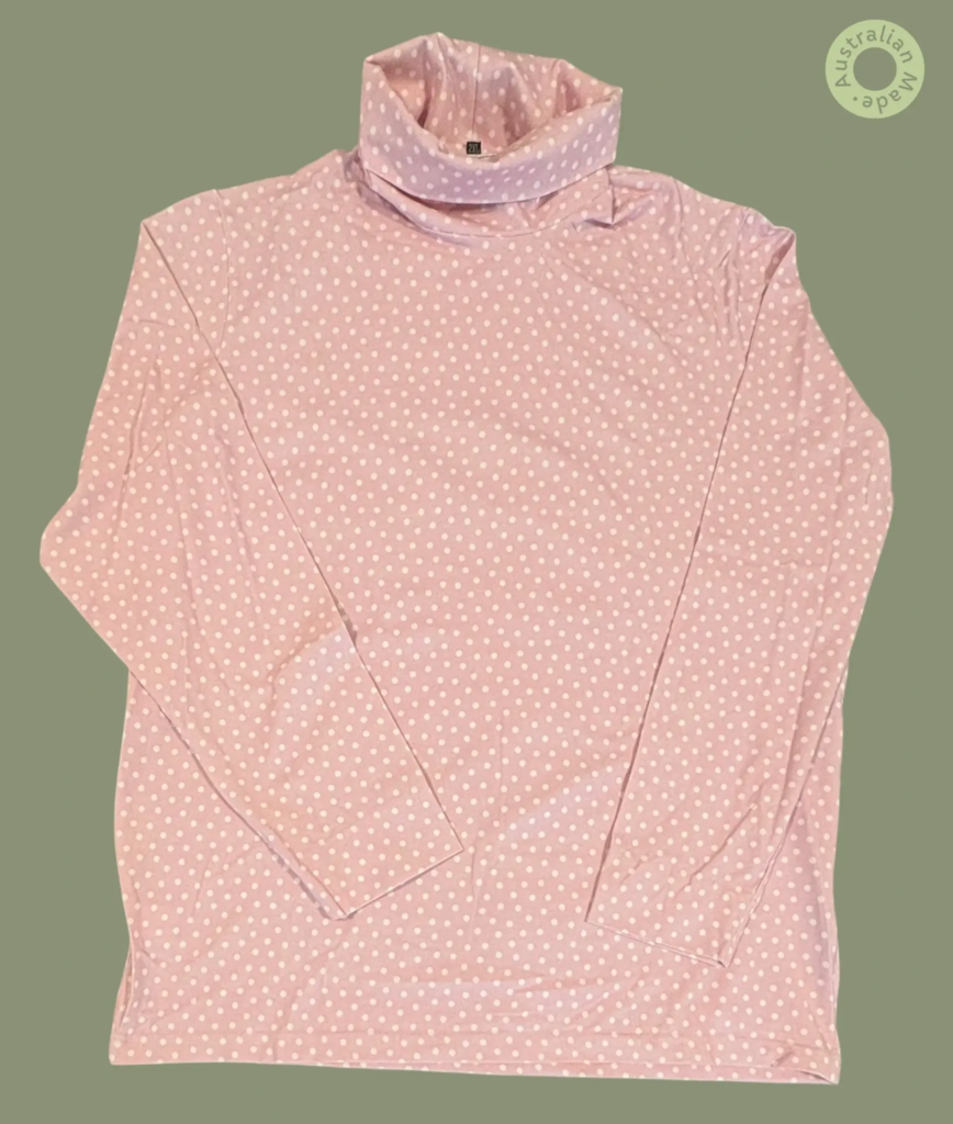 #604 – This top features a light pink base with a white polka dot pattern throughout th
