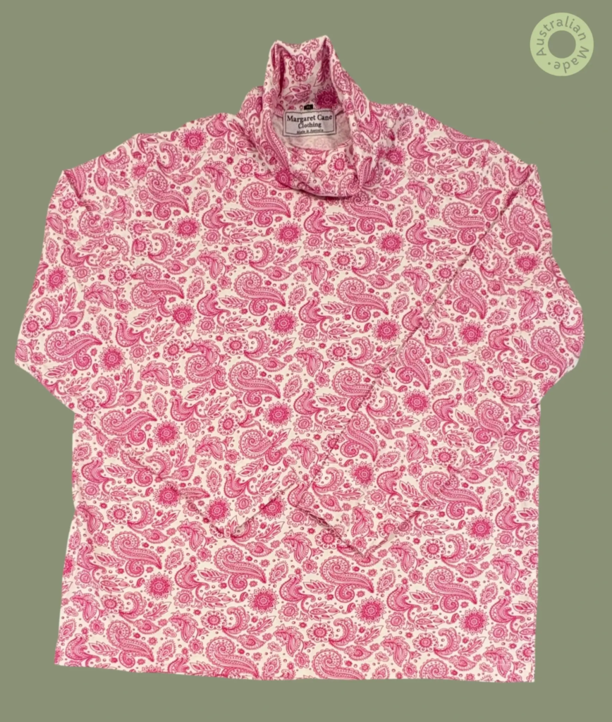 #605 – This top features a white base with a detailed pink paisley and floral pattern t