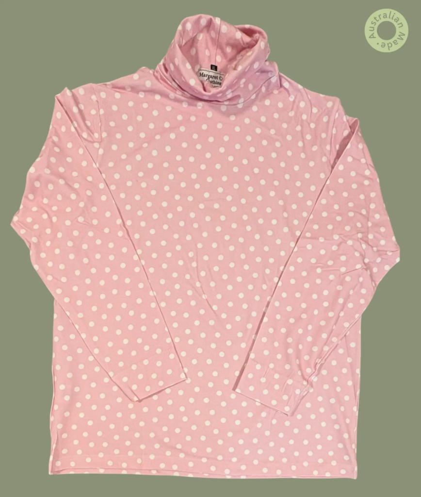 #610 – This top features a pink base with a large white polka dot pattern throughout th