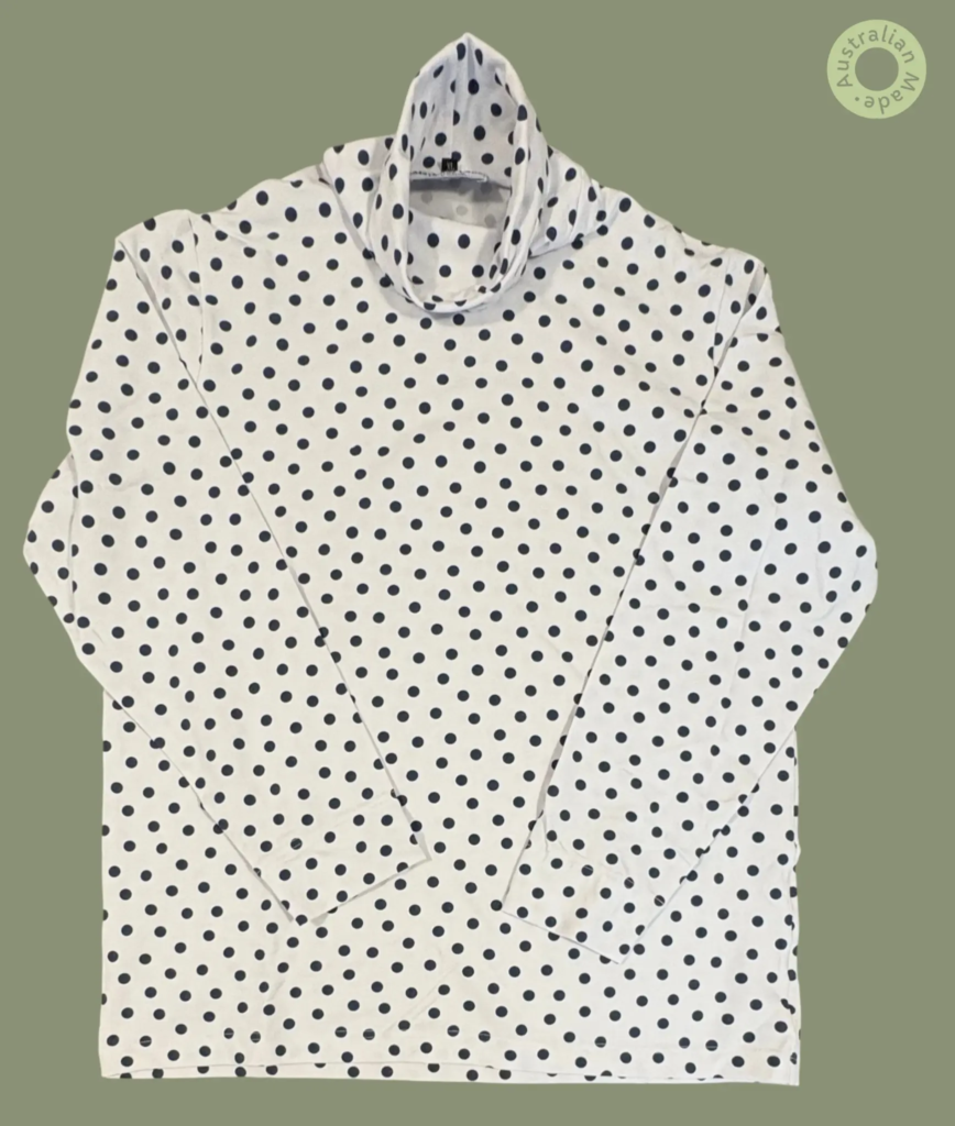 #611 – This top features a white base with a large navy polka dot pattern throughout th